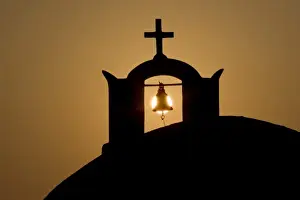 Greek Orthodox Prints: Greece, Santorini, Thira, Oia. Greek Orthodox church cross and bell tower in silhouette