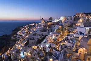 Prints of Greece, Santorini. The village of Oia glows in the post-sunset light as the towns lights add magic to this iconic scene Images Dated 2018 December: Greece, Santorini. The village of Oia glows in the post-sunset light as the town s
