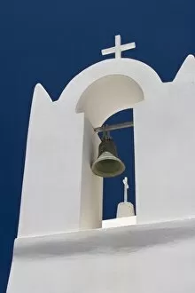 Greece, Santorini. White church bell tower against dark blue sky