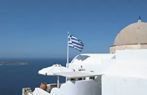 Porch Prints: Greek flag flying on porch of white home on steep clifees of Fira in Santorini in