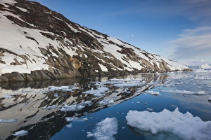 Greenland, Disko Bay, Ilulissat, floating ice at sunset with moonrise