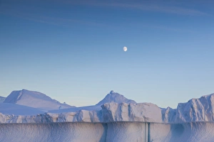 Greenland Collection: Greenland, Disko Bay, Ilulissat, floating ice at sunset with moonrise
