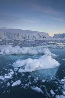 Greenland Collection: Greenland, Disko Bay, Ilulissat, floating ice at sunset with moonrise