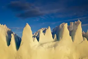 Greenland, Ilulissat, Setting midnight sun lights jagged floating iceberg near Eqip
