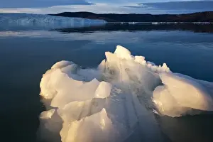 Images Dated 13th June 2010: Greenland, Ilulissat, Setting midnight sun lights small iceberg floating near Eqip