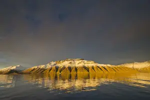 Inger Hogstrom Prints: Greenland. Kong Oscar Fjord. Deeply eroded mountains reflected in the calm water