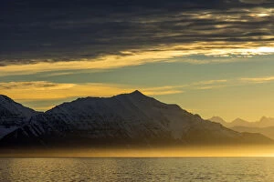 Greenland. Kong Oscar Fjord. Sunset over the calm water of the fjord