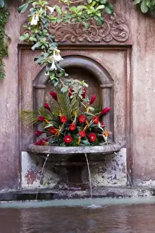Guatemala, Antigua. Fountain decorated with flowers in a hotel in the town of Antigua