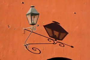 Sacatepequez Department Prints: Guatemala, Antigua. A lantern with shadow on a colorful wall in the town of Antigua