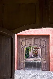 Sacatepequez Department Prints: Guatemala, Antigua. Looking through two doorways at a hotel fountain decorated with flowers