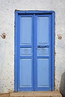 Hand prints on each side of blue doorway. Small rural village outside of Luxor, Egypt