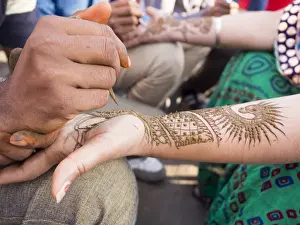 Holding Prints: Henna being applied on womans hand in Jaipur, Rajasthan, India