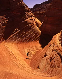 Hiker enjoys swirling Navajo Sandstone, Vermillion Cliffs area, Arizona