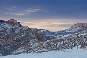 Horse drive in winter on Hideout Ranch, Shell, Wyoming. Big Horn Mountains range at dusk