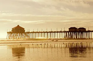 Surfing Prints: The Huntington Beach Pier and surfers at sunset. Huntington Beach, California