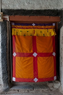 Tibetan Prints: India, Jammu & Kashmir, Ladakh, doorway covered by an orange, red and yellow curtain