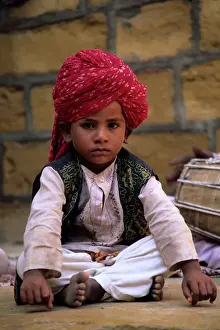 Cute Prints: India, Rajasthan, Jaisalmer. Boy dancer rests between songs at entrance to Jaisalmer Fort