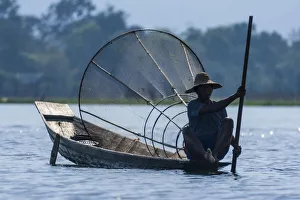 Inlay Lake, Shan State, Myanmar. Fisherman poles his canoe. (Editorial Use Only)