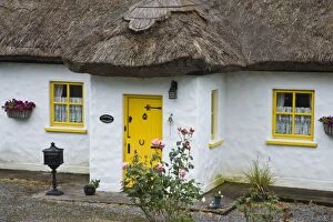 Ireland, Achill Island. Front door and windows of a thatch roof cottage