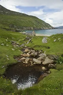 Shack Prints: Ireland, Achill Island. A stream runs down to the turquoise waters of Keem Bay past