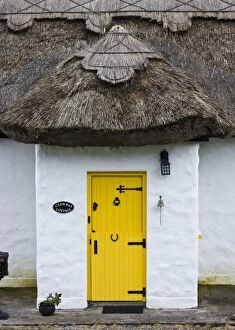 Ireland, Achill Island. Yellow doorway on a thatch roof cottage