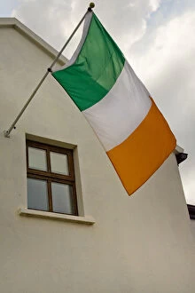 Ireland, County Mayo, Achill Island, Dooagh. The flag of Ireland flies from building
