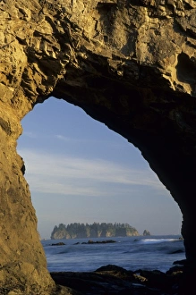 Island viewed through arch in sea stack, Rialto Beach, Olympic National Park, Washington Island viewed through arch in sea stack, Rialto Beach, Olympic National Park, Washington