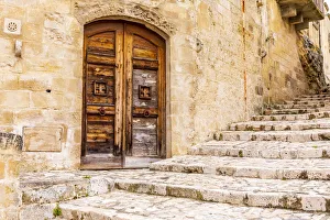 Stairway Prints: Italy, Basilicata, Province of Matera, Matera. Old wooden door in a stone wall above
