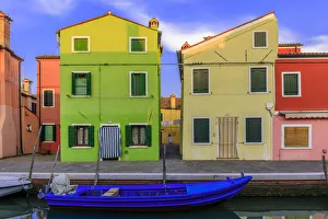 Prints of Italy, Burano. Colorful house walls and boat in canal. Credit as: Jim Nilsen / Jaynes Gallery / DanitaDelimont.com Images Dated 2018 December: Italy, Burano. Colorful house walls and boat in canal
