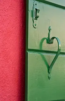 Handle Prints: Italy, Burano. Handle on green shutter contrasts with red wall