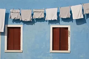Images Dated 20th May 2006: Italy, Burano. Hanging laundry and windows along blue wall