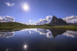 Italy, Dolomites, Giau Pass. Sun reflection in mountain tarn