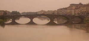 Italy, Florence. A nostalic, foggy view of a bridge over the Arno River
