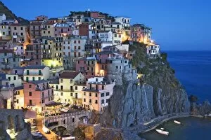 Images Dated 27th May 2006: Italy, Manarola. Dusk falls on a hillside town overlooking the Mediterranean Sea