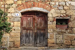 Monteriggioni Prints: Italy, Monteriggioni. Stone wall, wooden door with planted geraniums