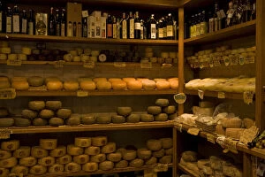 Italy, Tuscany, Pienza. Aged cheese wheels for sale in a shop