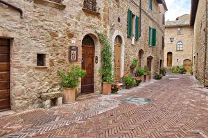 Images Dated 14th February 2022: Italy, Tuscany, Pienza. Flower pots and potted plants decorate a narrow street in a Tuscany village