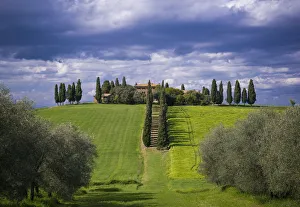 Italy, Tuscany, Val d Orcia. Farmhouse and storm clouds at sunset