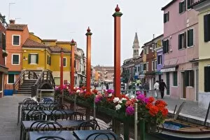 Italy, Venice, Burano. Cafe tables along the canal