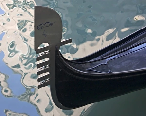 Images Dated 18th March 2005: Italy, Venice. Close-up of ornate prow of gondola with water reflections