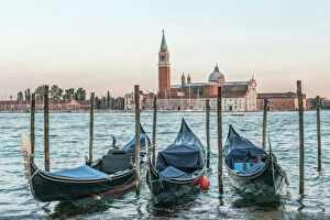 Italy, Venice. Gondolas on the waterfront with San Giorgio Maggiore Church in the