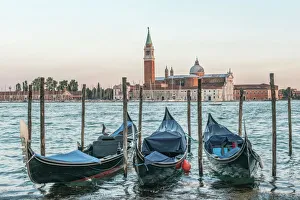Italy, Venice. Gondolas on the waterfront with San Giorgio Maggiore Church in