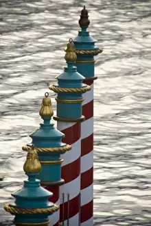 Parking Prints: Italy, Venice. A line of gondola parking poles striped in red and white