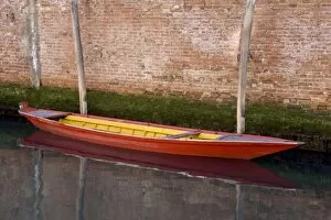 Italy, Venice. Red boat reflecting in canals still water