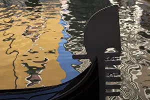 Images Dated 19th May 2010: Italy, Venice. The silhouette of a gondola against a background of colorful water
