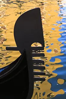 Images Dated 19th May 2010: Italy, Venice. A silhouette of a gondola against colorful water reflections