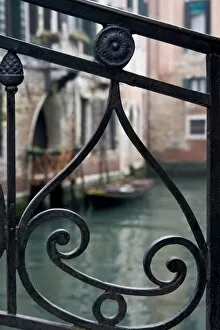 Italy, Venice. Stair railing metalwork design frames canal with gondola