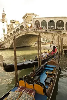 Italy; Venice. Tourists ride in gondolas on the Grand Canal near the Rialto Bridge