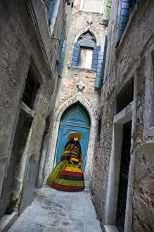 Mask Prints: Italy, Venice. Woman dressed for annual Carnival festival stands in narrow passage