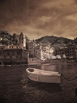 Prints of Italy, Vernazza. Infrared image of a boat in the harbor of Vernazza with the church in background Images Dated 2019 December: Italy, Vernazza. Infrared image of a boat in the harbor of Vernazza with the church in